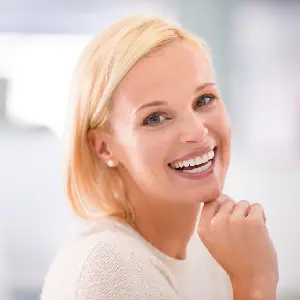 Smiling blonde woman resting her chin on her hand