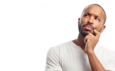 Man with hand on his face looking up and thinking