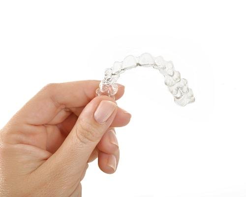 Hand holding tray of clear braces in Towson MD