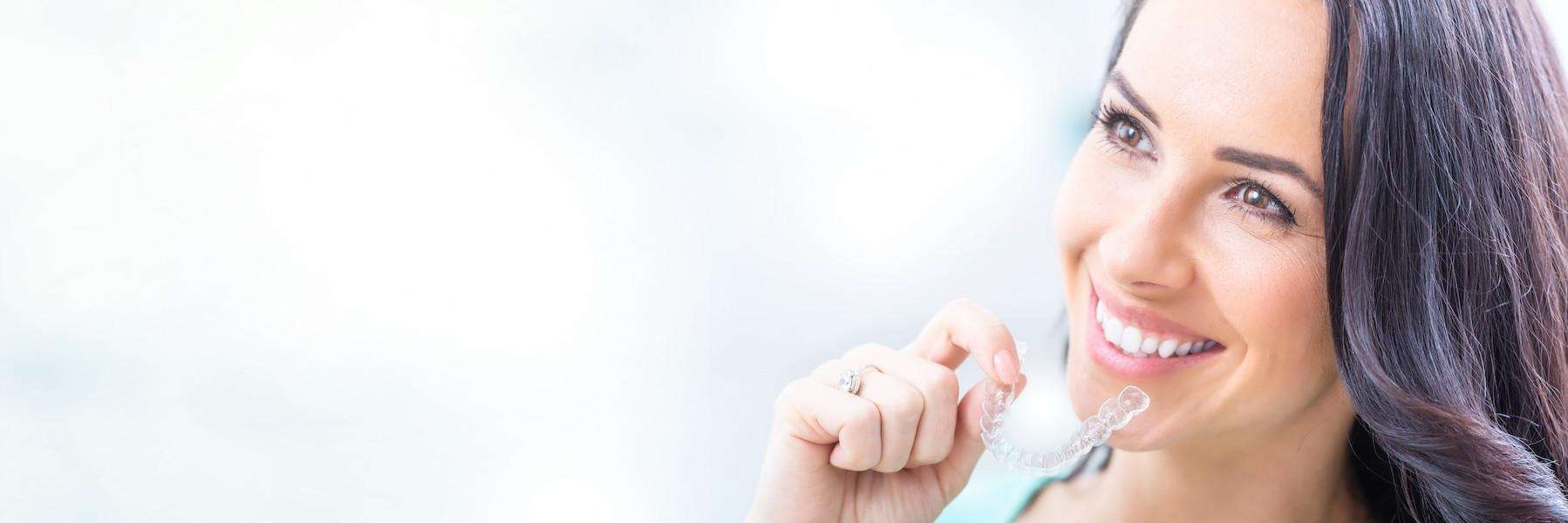 Dental patient putting on invisible braces in Towson, MD