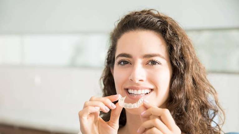Woman holding tray of clear aligners in Towson, MD