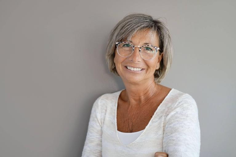 Woman with dental implants smiling at dentist in Towson, MD