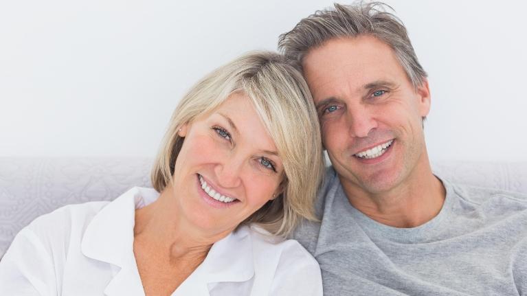 Married couple smiling on couch at dentist near me Towson