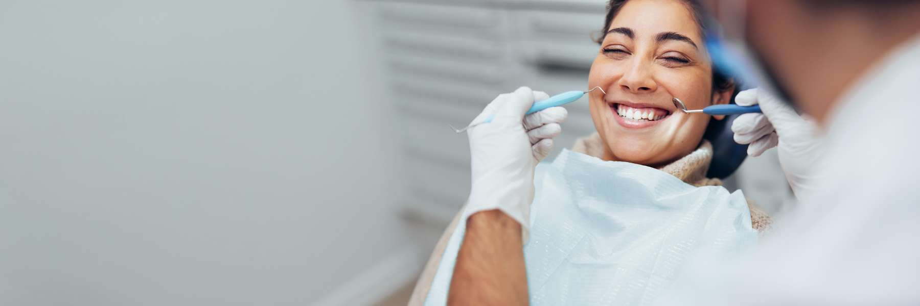 Woman smiling during exam and cleaning at dentist in Towson, MD